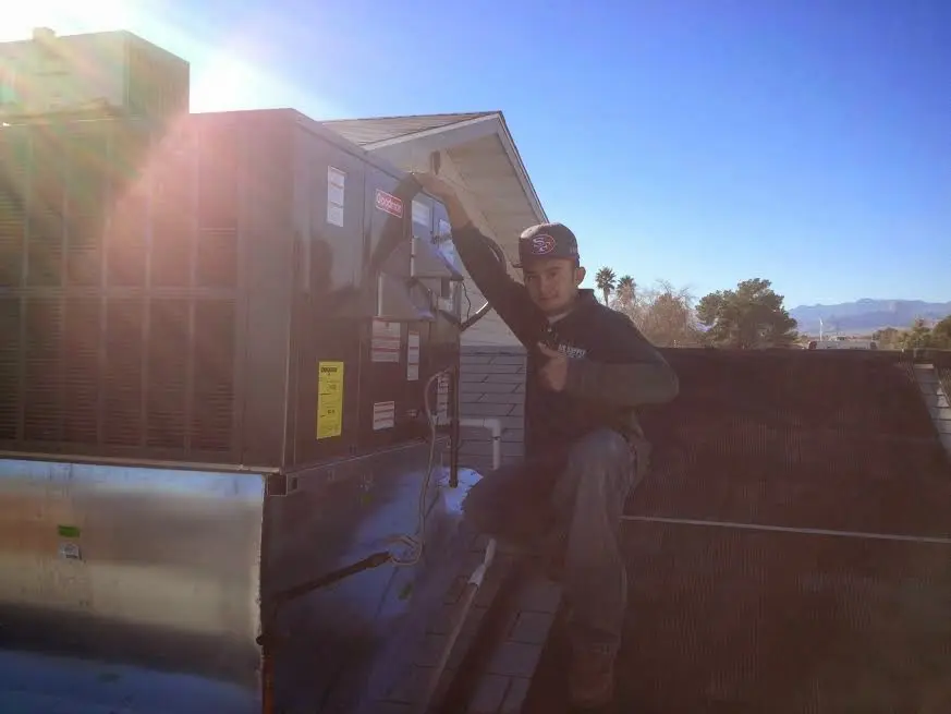 HVAC technician performing Heat Pump Repair on a rooftop unit in Schaumburg